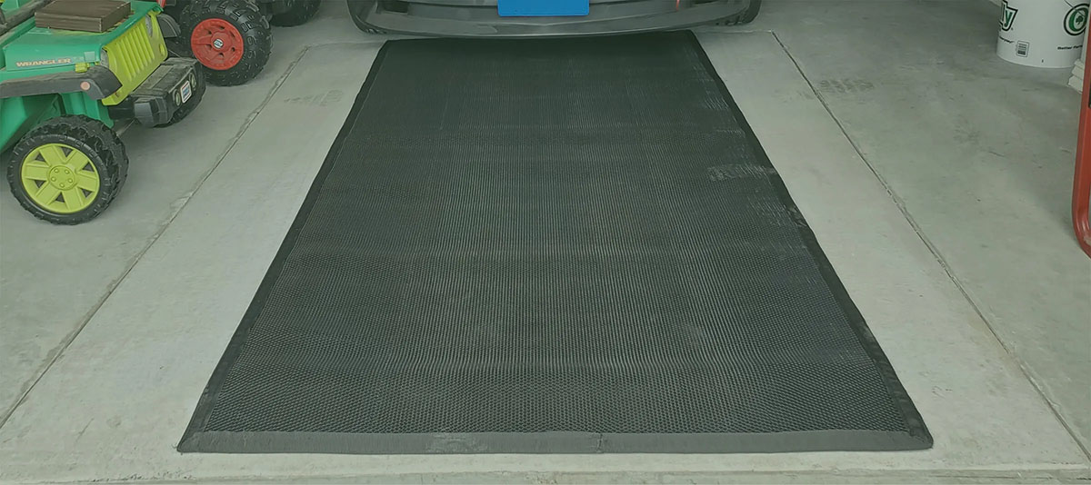 Take Cover breathable storm shelter cover installed flush in residential garage floor with vehicle parked on top.